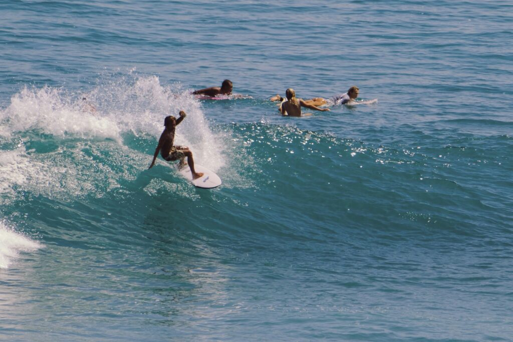 Uluwatu Bali dengan ombak sempurna dan peselancar bersiap di garis ombak