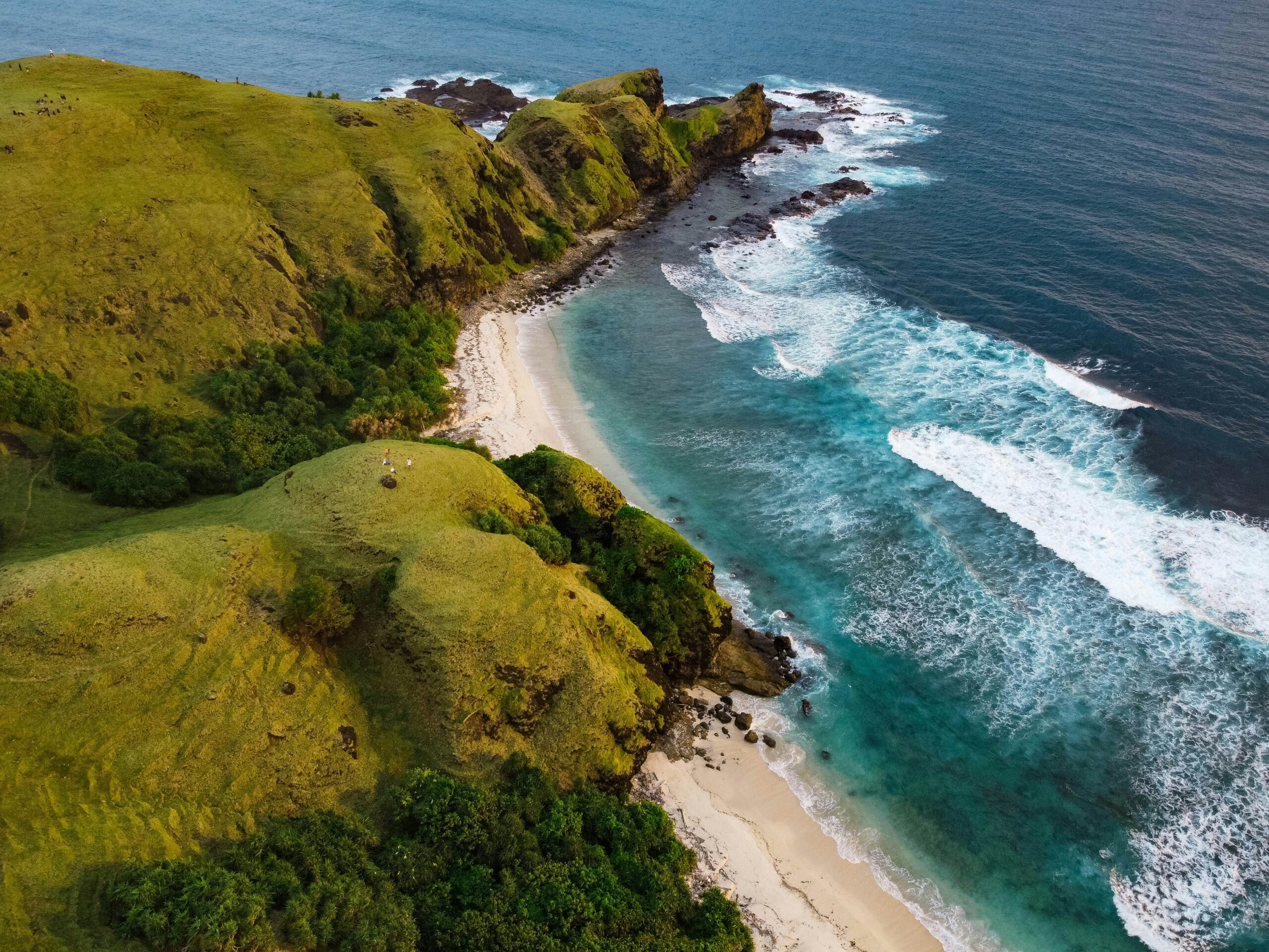 Pantai Kuta Mandalika dengan pasir putih unik dan perbukitan di latar belakang.